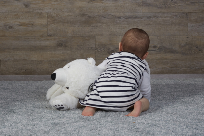 Baby krabbelnd von hinten mit Eisbär